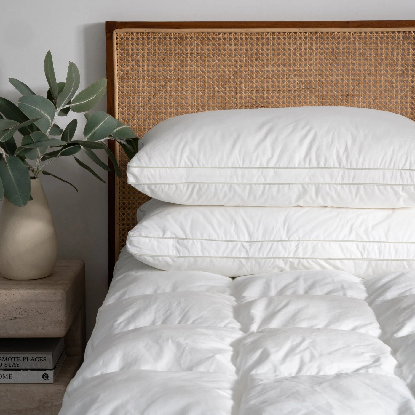 Two Signature Deluxe Suite Pillows stacked on a white bed